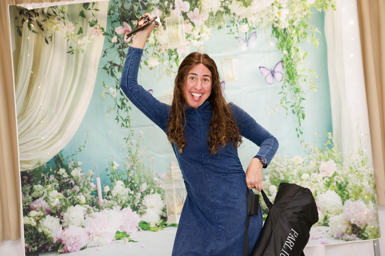 DJ Shira celebrating with a microphone at a floral event